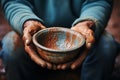 Aged hands clutch empty bowl, selective focus conveying the harshness of poverty Royalty Free Stock Photo