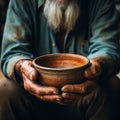 Aged hands clutch empty bowl, selective focus conveying the harshness of poverty Royalty Free Stock Photo