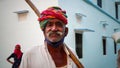 Aged Indian man with handlebar moustache wears a red and green Rajasthani turban and poses for the camera Royalty Free Stock Photo