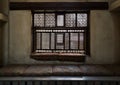 Aged interleaved wooden window and a built-in couch Royalty Free Stock Photo