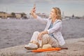 Aged lady takes photos near river