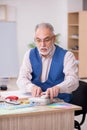 Old male designer working in the office Royalty Free Stock Photo