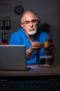 Aged male doctor in the hospital at night