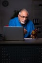 Aged male doctor in the hospital at night