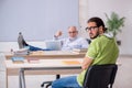 Old male teacher and young male student in the classroom Royalty Free Stock Photo