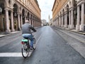 Aged man biking in deserted city for nationwide lockdown caused by Coronavirus epidemic emergency