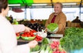 Aged man customer buying vegetables in open-air market