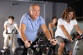 Aged man doing cardio workout on exercise bike in gym Royalty Free Stock Photo