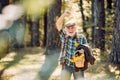 Aged man pick flowers in basket. Portrait of aged man with beard. Funny grandfather in hat in forest. Old tourist