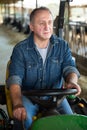 Aged man on small farm tractor Royalty Free Stock Photo