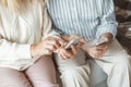 Senior couple together at home retirement concept sitting browsing smartphone touching close-up