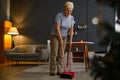 Aged mature woman sweeping floor at home Royalty Free Stock Photo
