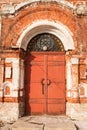 Aged Old Red Metal Door With Lock On Old Brick Facade. Royalty Free Stock Photo