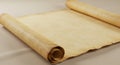 An aged, open scroll made of parchment or vellum lies on a light beige surface. The Royalty Free Stock Photo