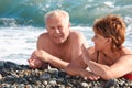 Aged pair lie on pebble beach