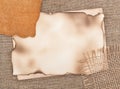 Aged paper with piece of leather on sacking background Royalty Free Stock Photo