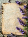 Aged parchment with a natural, cracked surface surrounded by fragrant lavender flowers, suitable for vintage-themed Royalty Free Stock Photo