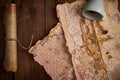 Aged parchment scroll with old maps and a spilled coffee cup on a wooden table. Royalty Free Stock Photo