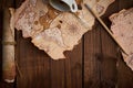 Aged parchment scroll with old maps and a spilled coffee cup on a wooden table. Royalty Free Stock Photo