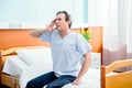 Aged patient with headache sitting on bed in chamber in hospital Royalty Free Stock Photo