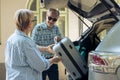 Aged people loading trolley in car trunk Royalty Free Stock Photo