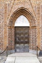 Aged planks with old rivets, bolts, door handle. The gothic door in the medieval teutonic knights castle Malbork, Poland. Royalty Free Stock Photo