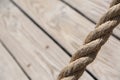 Aged rope with wooden floor boards in the background creating a natural aged texture for use as a background. Royalty Free Stock Photo