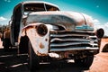 Aged, rusted truck on an unpaved country road with clear skies above on a sunny day