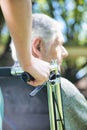 Aged senior man on the wheelchair assisted by nurse, detail on woman`s hand