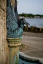 Aged stone bird fountain dripping water on a bridge