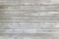 Aged surface of horizontal wooden planks with cracked white paint. Peeling paint on an old wooden wall Royalty Free Stock Photo