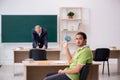 Aged teacher and male lazy student in the classroom Royalty Free Stock Photo