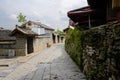 Aged tile-roofed houses along stone street in cloudy spring