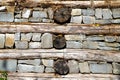 Old wall made of natural stone and wood logs. Abstract background.
