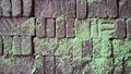 Aged and weathered bricks are covered in vibrant green moss, forming a unique texture and pattern on this old wall background Royalty Free Stock Photo