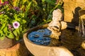 .Aged white angel Cupid sculpture sitting water fountain.Thailand