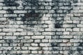 Aged white painted brick wall texture. Old textured grunge wall surface background pattern of masonry. Cracks and black stains. Royalty Free Stock Photo