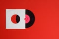 Aged White paper cover and vinyl LP record isolated on Red background. 45rpm Vinyl Record with Sleeve. Royalty Free Stock Photo