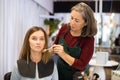 Aged woman beautician applying makeup to young female client Royalty Free Stock Photo