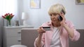 Aged woman calling children asking for help with using banking card, generation Royalty Free Stock Photo