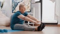 Aged woman doing stretching exercise on yoga mat Royalty Free Stock Photo