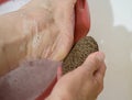 Woman rubbing heel of foot with pumice stone Royalty Free Stock Photo