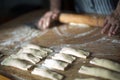 Aged woman`s hands with a rolling pin preparing at home casadielles filled with nuts. Tradicional gastronomy