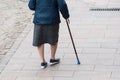 aged woman walking with stick in the street on back view Royalty Free Stock Photo