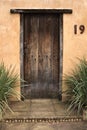 Aged wooden door set in terracotta wall. number 19.