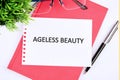 AGELESS BEAUTY text written on a white sheet of a notebook Royalty Free Stock Photo