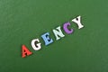 AGENCY word on green background composed from colorful abc alphabet block wooden letters, copy space for ad text. Learning english Royalty Free Stock Photo