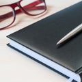 Agenda, pen and glasses on a wooden table. Royalty Free Stock Photo
