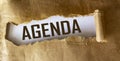 Agenda, text is written on torn brown paper. Royalty Free Stock Photo
