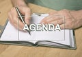 Agenda word. Inscription on photo of hands writing in planner or organizer Royalty Free Stock Photo